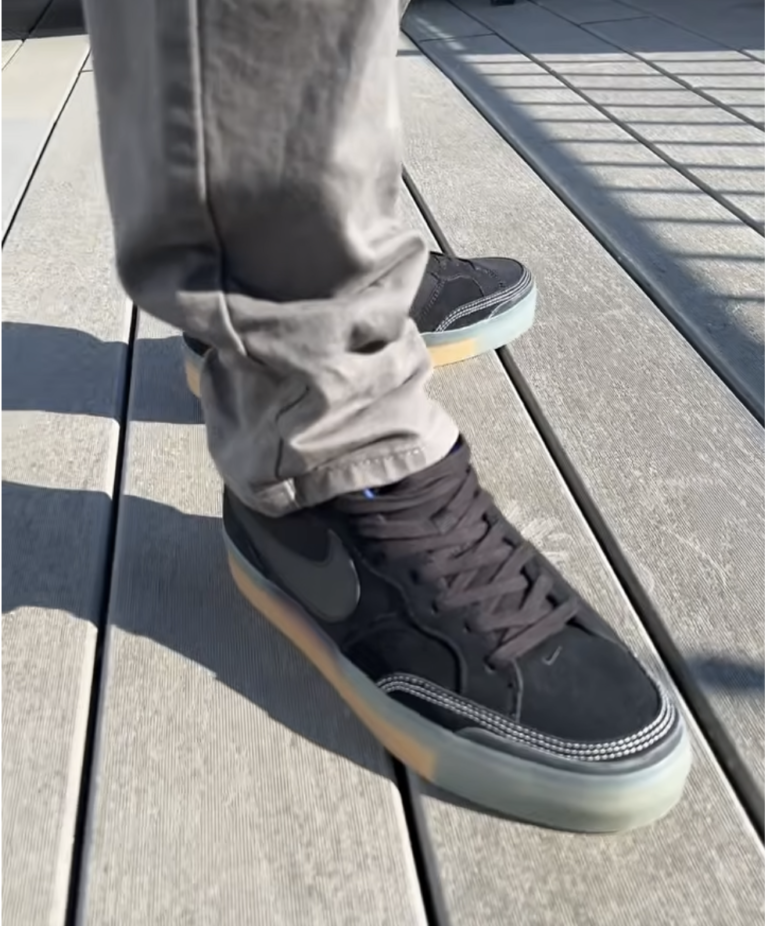 The Nike SB Pogo Plus Premium (Black Gum) worn on feet with grey pants