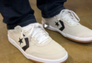 The CONS Louie Lopez Pro 2 Suede in Egret/White/Orange on feet worn with straight fit dark blue jeans