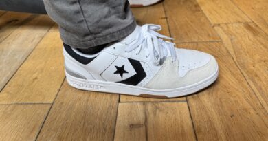 The Converse CL 98 in white grey black on feet worn with grey pants on hardwood floor