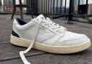 Close up of the the Men’s Vans Court Low Shoe leather white and navy blue with an offwhite outsole profile view