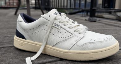 Close up of the the Men’s Vans Court Low Shoe leather white and navy blue with an offwhite outsole profile view