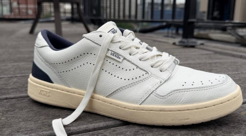 Close up of the the Men’s Vans Court Low Shoe leather white and navy blue with an offwhite outsole profile view